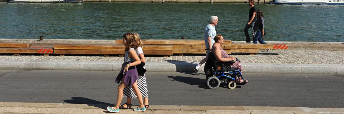 rue pietonne bord d'eau : personnes à pieds et fauteuil roulant - Ville accessible à tous